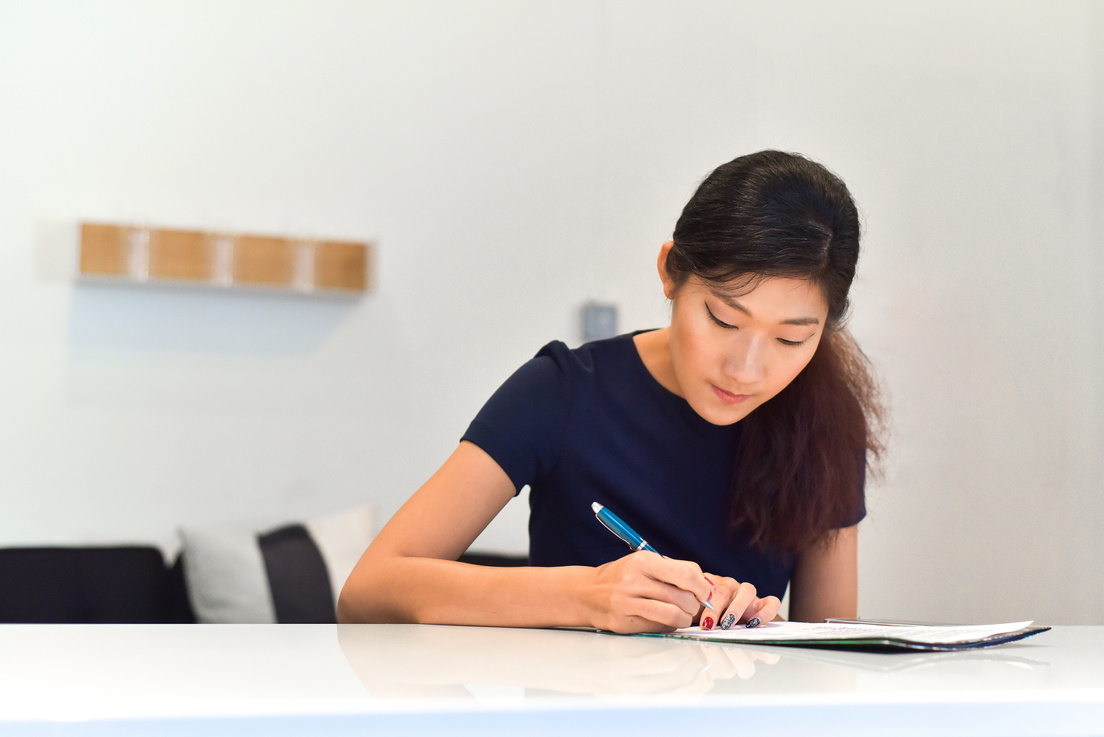 Asian Woman Writing Documents